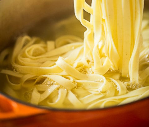 fresh fettuccine being cooked in water
